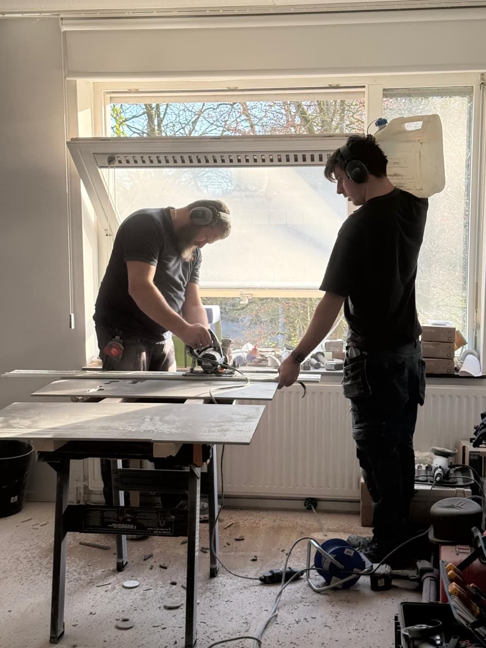 Twee monteurs passen een werkblad bij het raam